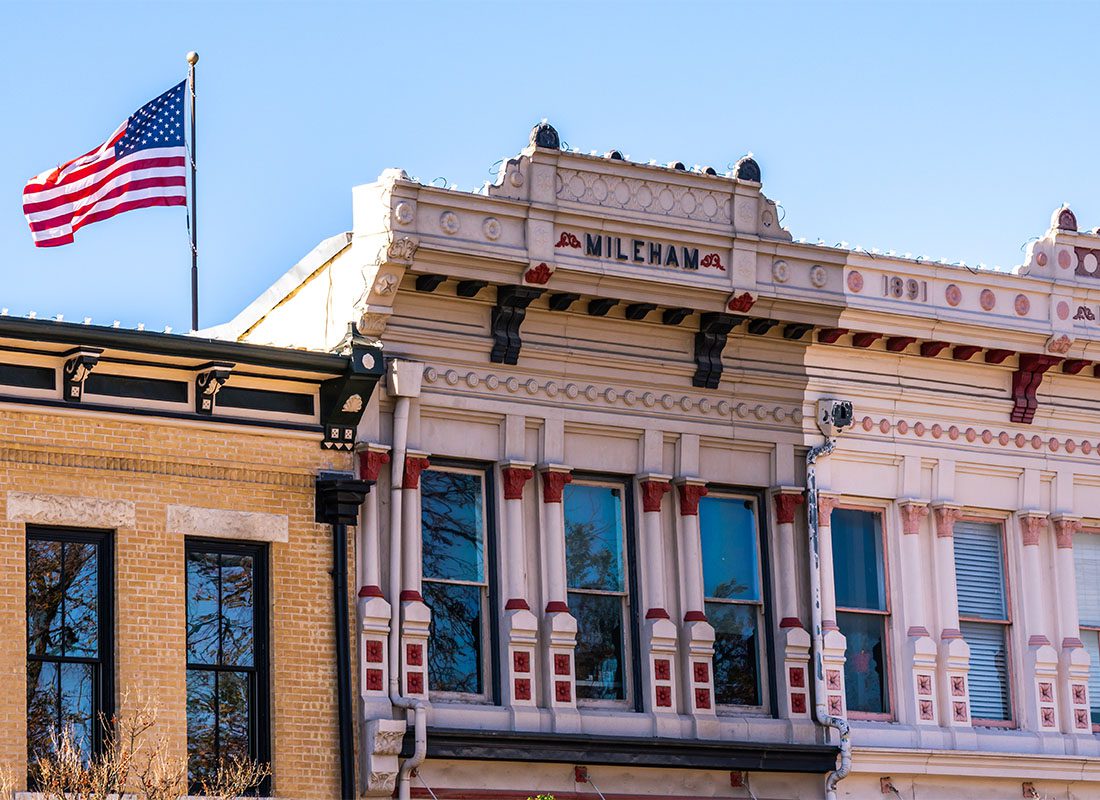 Georgetown, TX - Row of Historical Buildings in Downtown Georgetown Texas with an American Flag on the Roof Against a Clear Blue Sky