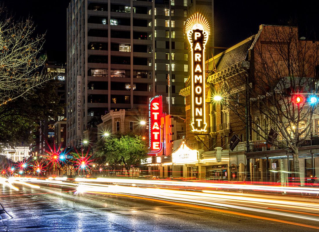 Read Our Reviews - View of a Row of Businesses Along a Main Street in Downtown Austin Texas at Night with Lights Shining All Around