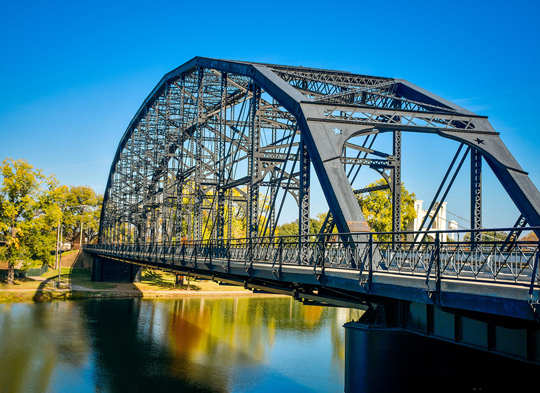 Waco, TX - Closeup View of the Washington Avenue Steel Bridge in Waco Texas Across a River on a Beautiful Sunny Day