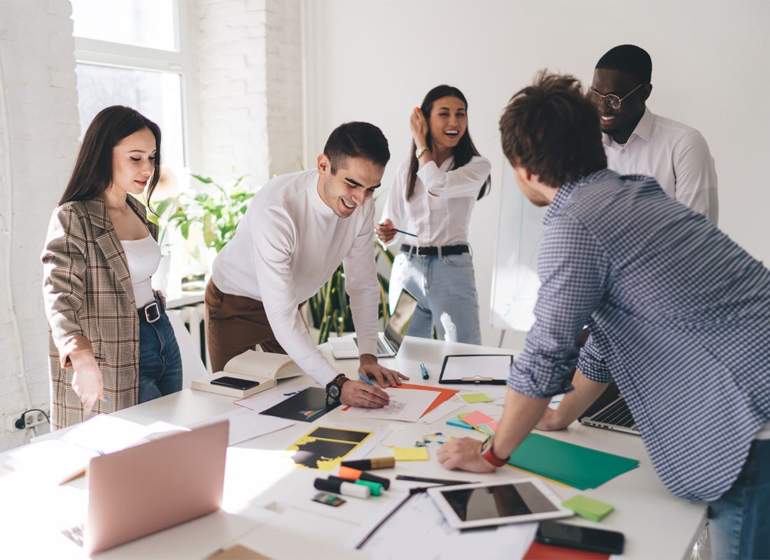 Wellness - View of a Cheerful Group of Young Business Professionals Working on a Project Together During a Meeting in a Conference Room in the Office